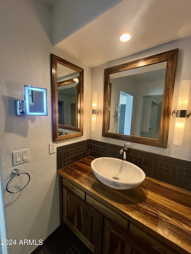 bathroom featuring vanity and tasteful backsplash