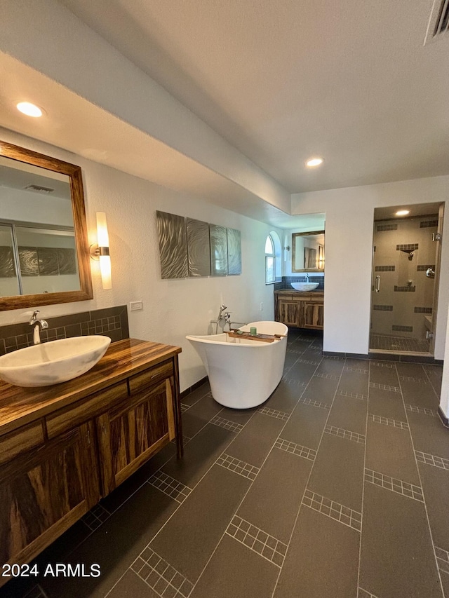 bathroom with tasteful backsplash, vanity, tile patterned floors, and plus walk in shower