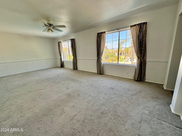 carpeted empty room featuring ceiling fan and a textured ceiling