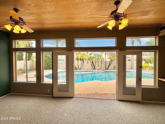 doorway featuring carpet flooring, a wealth of natural light, and ceiling fan