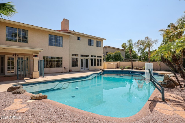 view of swimming pool with french doors and a patio