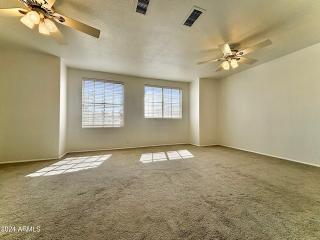 carpeted spare room with ceiling fan and a textured ceiling