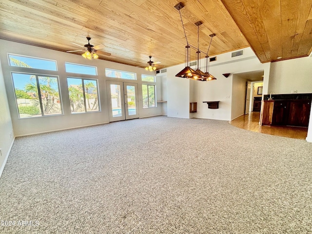 unfurnished living room featuring ceiling fan, light colored carpet, french doors, and wooden ceiling