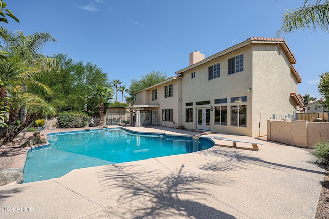 view of swimming pool with a patio area and a diving board