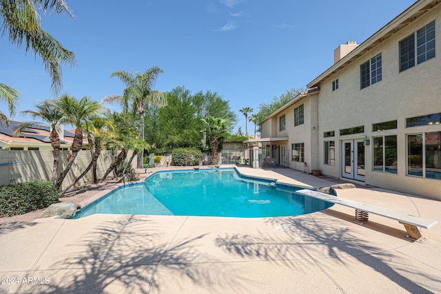 view of pool with a diving board and a patio area