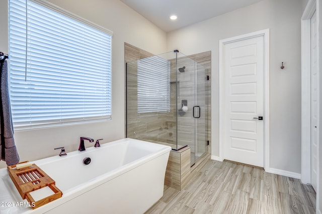 bathroom featuring separate shower and tub and a wealth of natural light