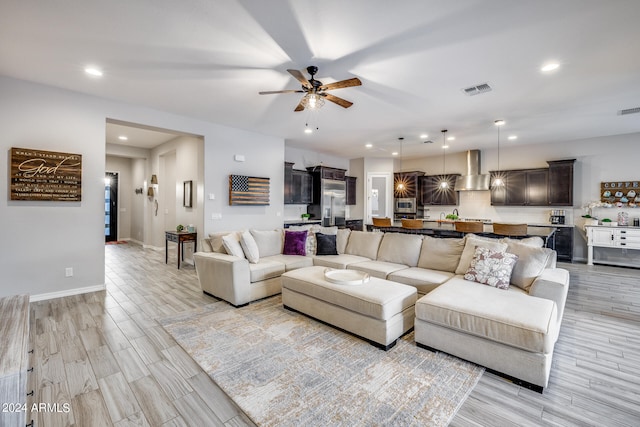 living room with ceiling fan and light hardwood / wood-style flooring