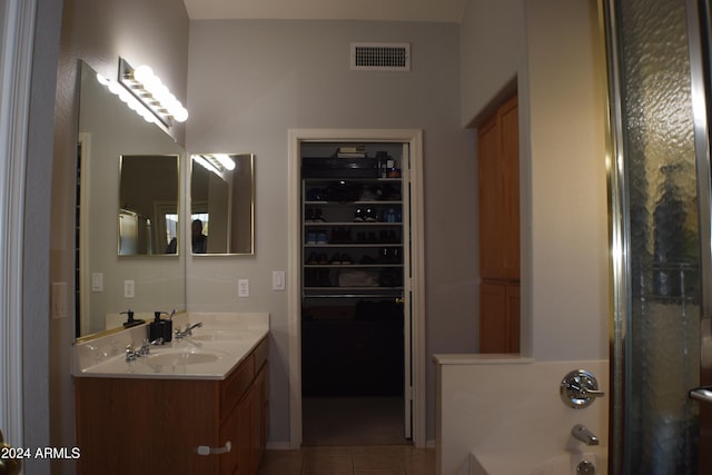 bathroom with tile patterned floors, vanity, and a tub