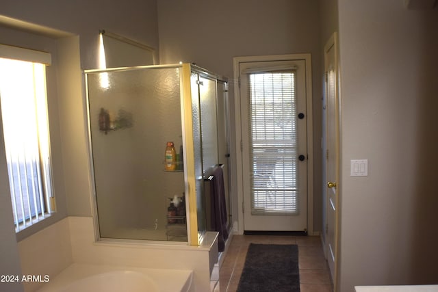 bathroom featuring tile patterned flooring, plus walk in shower, and a healthy amount of sunlight