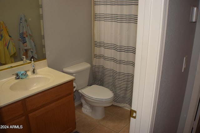 bathroom featuring tile patterned flooring, vanity, curtained shower, and toilet