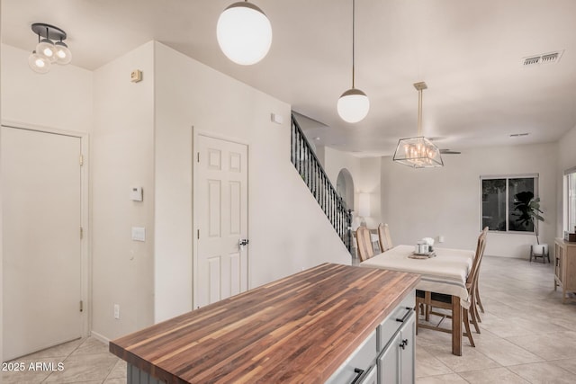 dining area with light tile patterned flooring, visible vents, and stairway