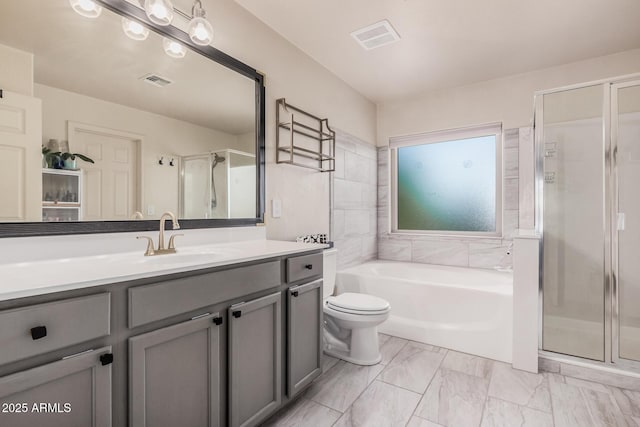 bathroom featuring vanity, a stall shower, a garden tub, and visible vents