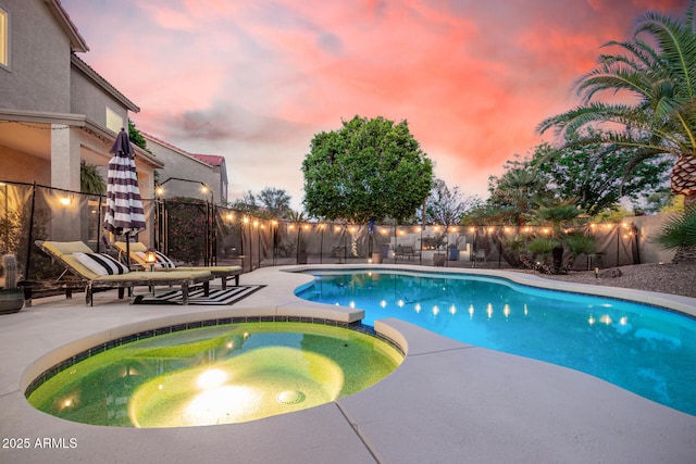 view of swimming pool featuring a patio, a pool with connected hot tub, and fence