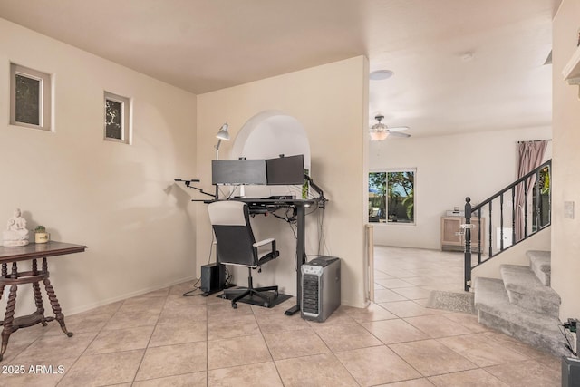 interior space with baseboards, ceiling fan, and stairs
