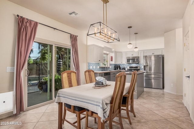 dining area featuring light tile patterned floors, a chandelier, and visible vents