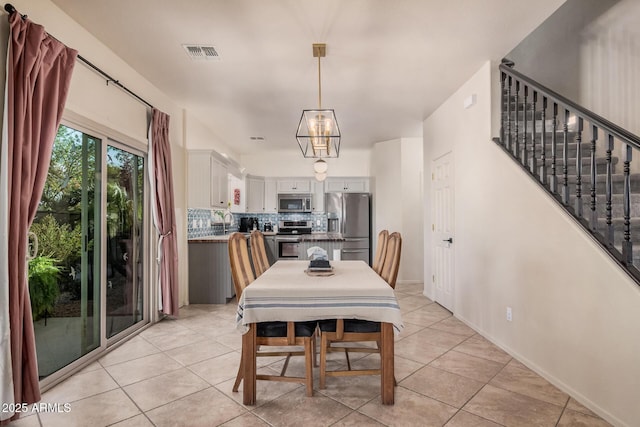 dining room featuring stairs, light tile patterned flooring, baseboards, and visible vents