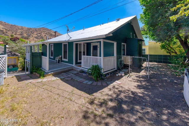 514 Brophy Ave, Bisbee, AZ 85603 - view of front of home with covered porch, fence, metal roof, and a mountain view