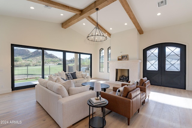 living room with a mountain view, high vaulted ceiling, an inviting chandelier, light hardwood / wood-style flooring, and beam ceiling