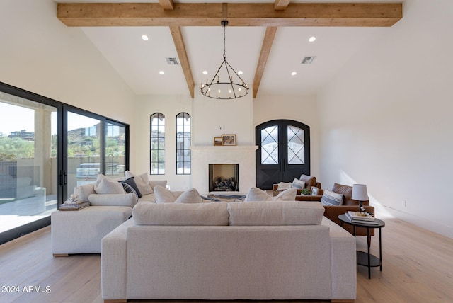 living room with french doors, light wood-type flooring, beam ceiling, high vaulted ceiling, and a chandelier