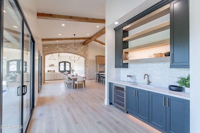 kitchen featuring sink, wine cooler, vaulted ceiling with beams, decorative light fixtures, and decorative backsplash