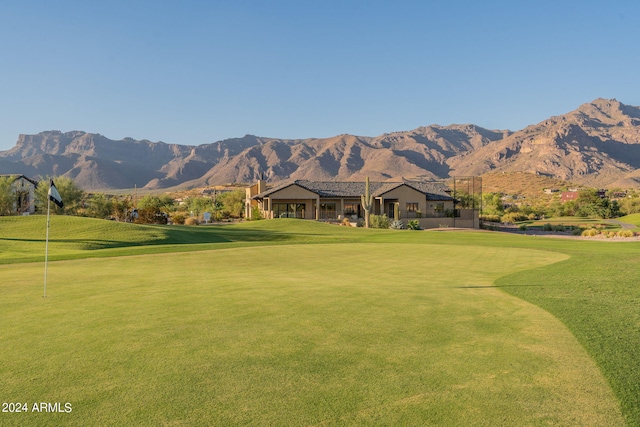 view of home's community with a mountain view, golf course view, and a yard