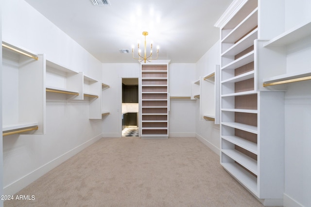 spacious closet featuring a notable chandelier and light carpet