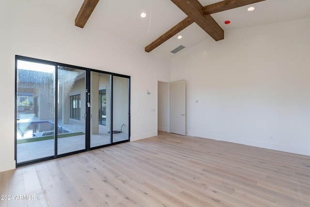 unfurnished room with beam ceiling, light wood-type flooring, and high vaulted ceiling