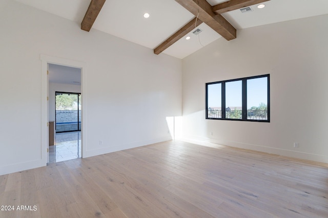 spare room with vaulted ceiling with beams and light wood-type flooring