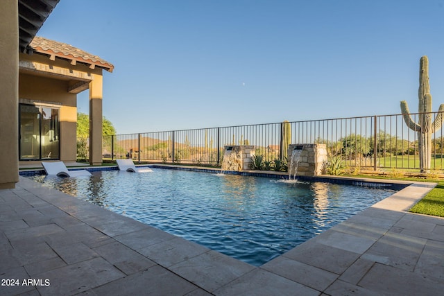 view of swimming pool with pool water feature