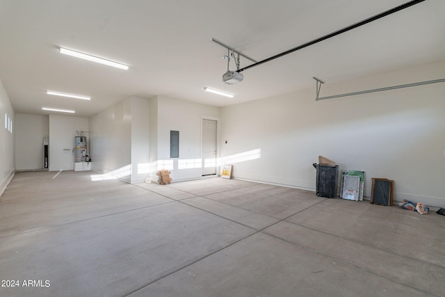 garage with secured water heater, a garage door opener, and electric panel