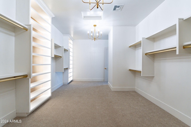 spacious closet with light carpet and an inviting chandelier