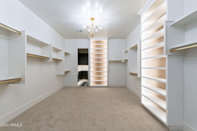 walk in closet featuring a notable chandelier and light carpet