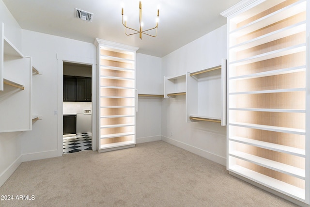 spacious closet with light carpet and a chandelier