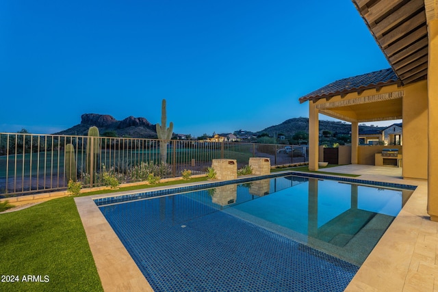 view of swimming pool featuring a patio and a water and mountain view