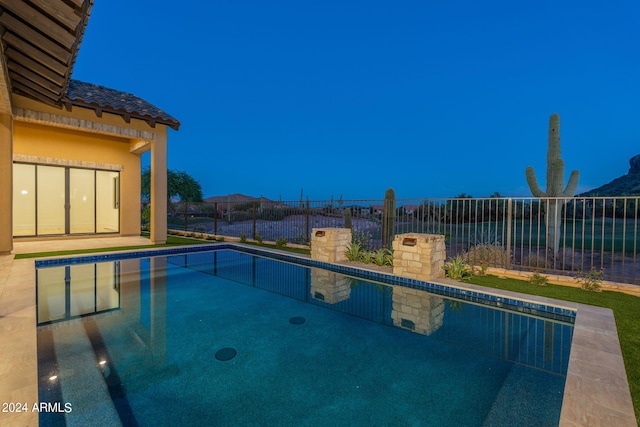 pool at dusk featuring a mountain view