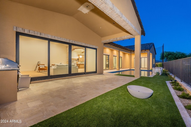 rear view of property featuring a fenced in pool and a patio area