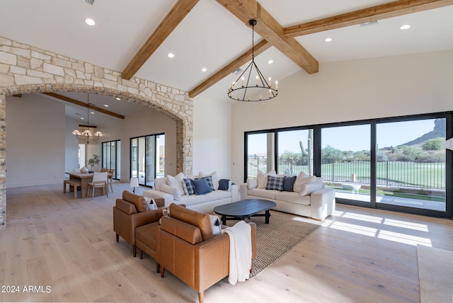 living room with high vaulted ceiling, an inviting chandelier, a water view, light hardwood / wood-style floors, and beam ceiling