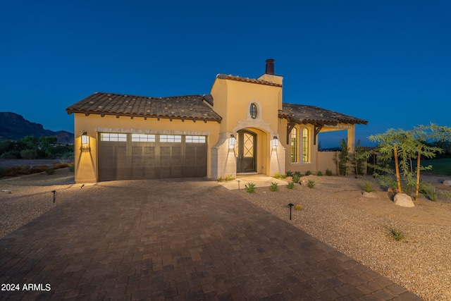 mediterranean / spanish-style home with a mountain view and a garage