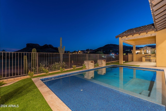 view of swimming pool with a mountain view and exterior kitchen