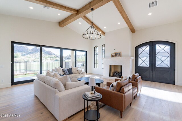 living room with french doors, an inviting chandelier, light hardwood / wood-style flooring, beamed ceiling, and high vaulted ceiling