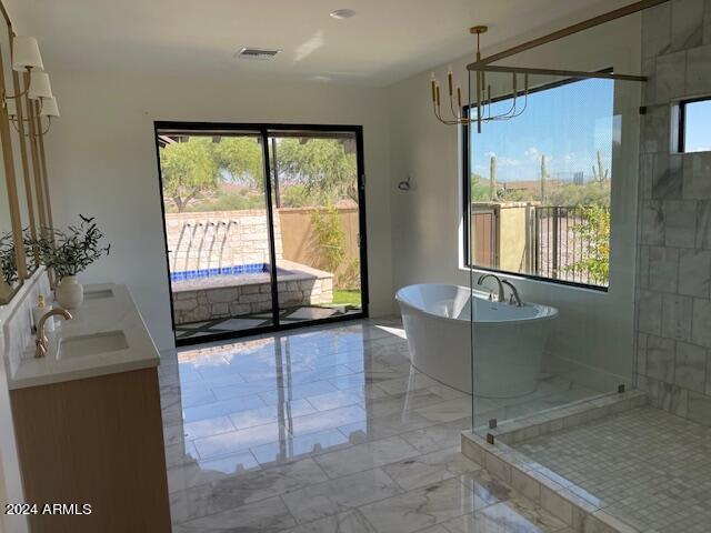 bathroom with plus walk in shower, vanity, and a chandelier