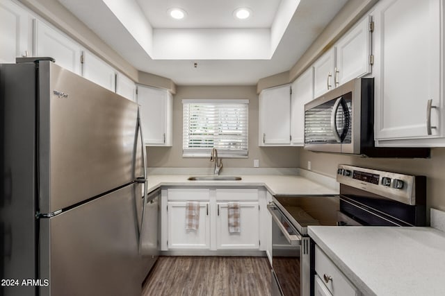 kitchen featuring dark wood-type flooring, sink, appliances with stainless steel finishes, and white cabinets