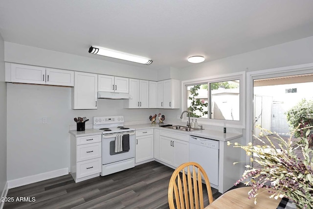kitchen with a sink, under cabinet range hood, white appliances, and light countertops