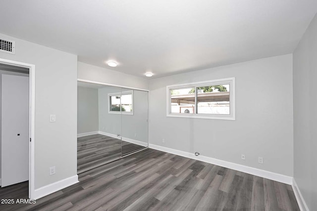 interior space with baseboards, visible vents, and dark wood-type flooring