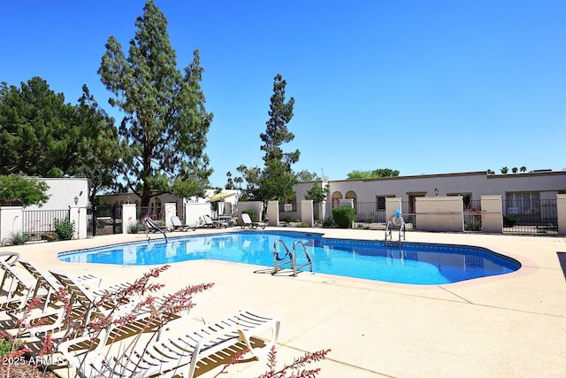community pool with fence and a patio area