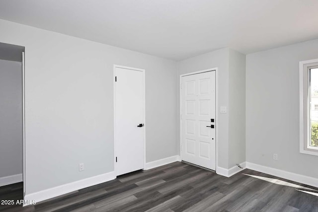 empty room featuring dark wood-style flooring and baseboards