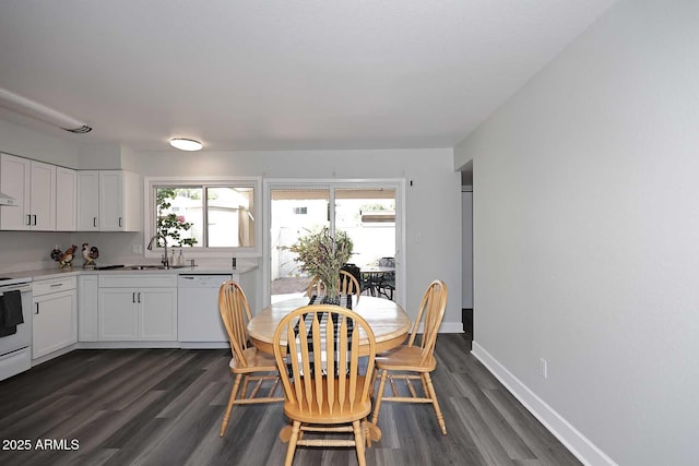 dining space with baseboards and dark wood finished floors