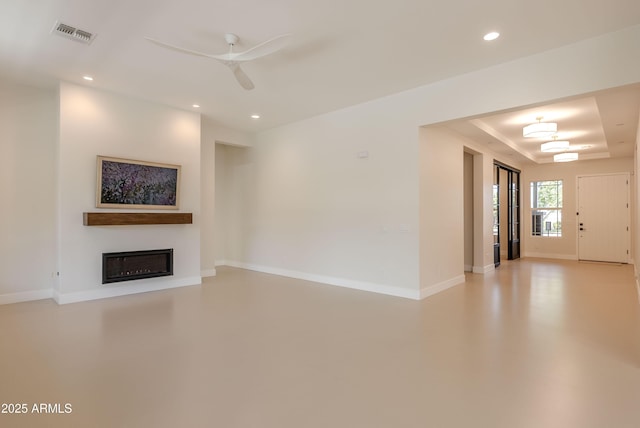 3145 E Boot Track Trl, Gilbert, AZ 85296 - unfurnished living room featuring recessed lighting, a glass covered fireplace, baseboards, ceiling fan, and a tray ceiling