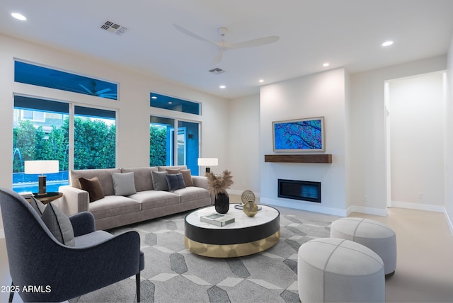 living area with visible vents, recessed lighting, a glass covered fireplace, and ceiling fan