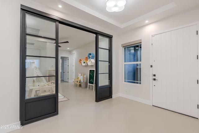 entrance foyer featuring baseboards, concrete flooring, and recessed lighting